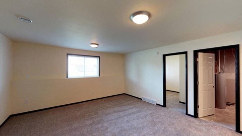 A room with a carpeted floor and a window.