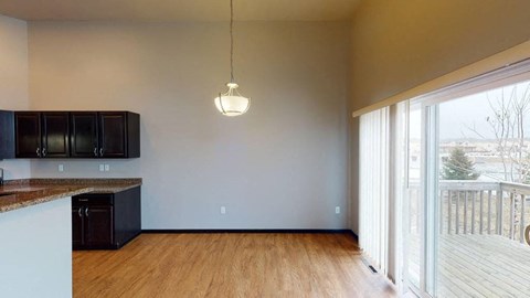 A kitchen with black cabinets and a wooden floor.