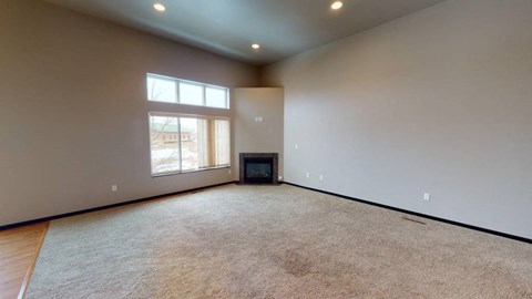 A spacious room with a flat screen TV and a window.