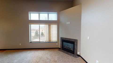 A room with a fireplace and a window showing a snowy landscape outside.