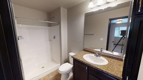 A bathroom with a toilet, sink, and shower.
