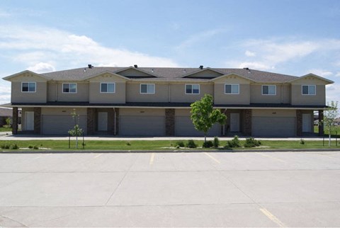 A large, multi-story building with a flat roof and a garage door on each floor.