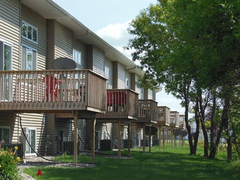 Apartment complex with balconies and trees in the background.