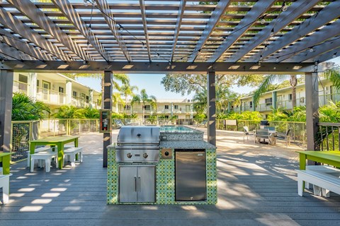 A BBQ grill is in the middle of a patio.