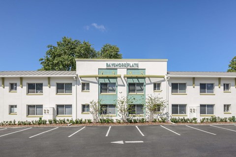 A white building with a green awning and the words "Bayshore Plaza" on the front.