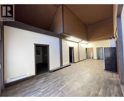 a large kitchen with white cabinets and a wood floor