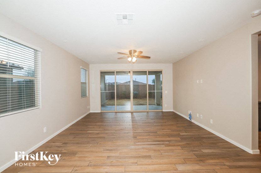 A spacious room with wooden floors and a ceiling fan.