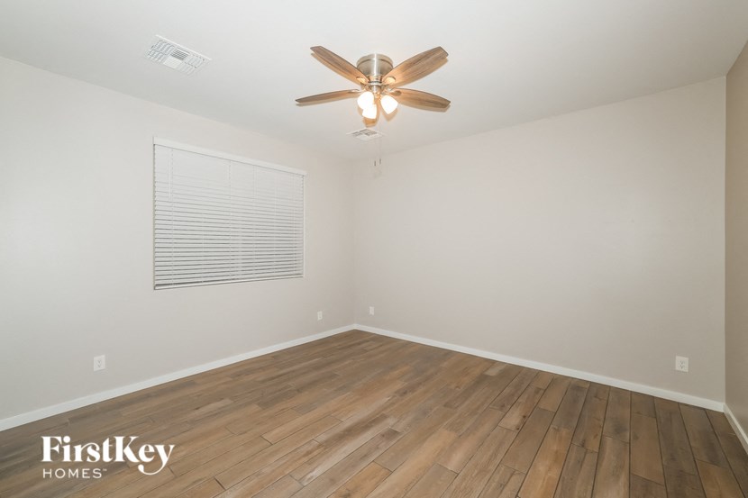 A room with wooden floors and a ceiling fan.