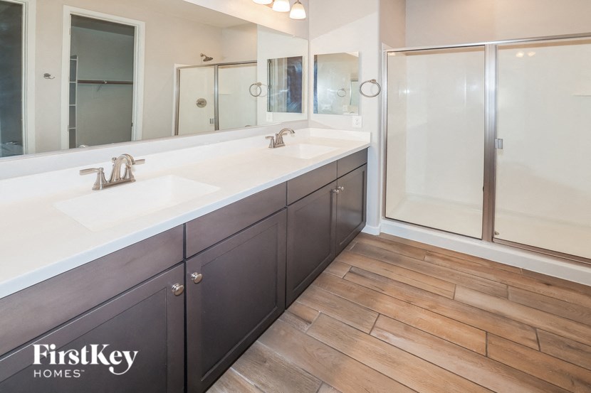A bathroom with a double sink and a walk-in shower.