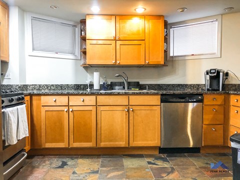 A kitchen with wooden cabinets and a granite countertop.