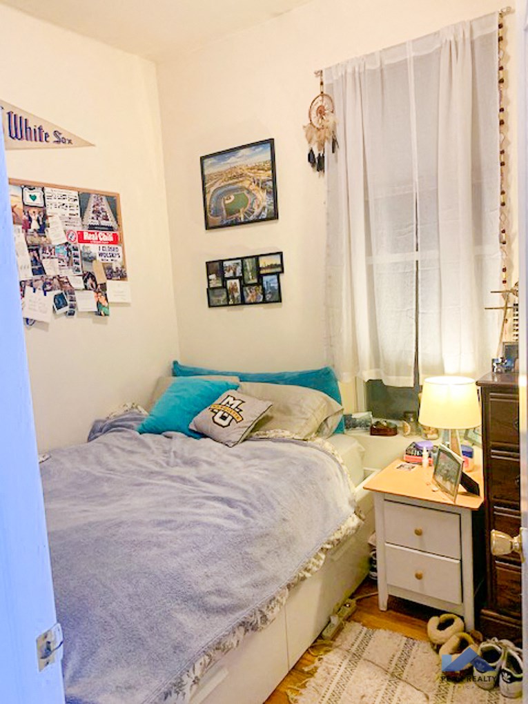 a bedroom with a bed with blue pillows and a night stand