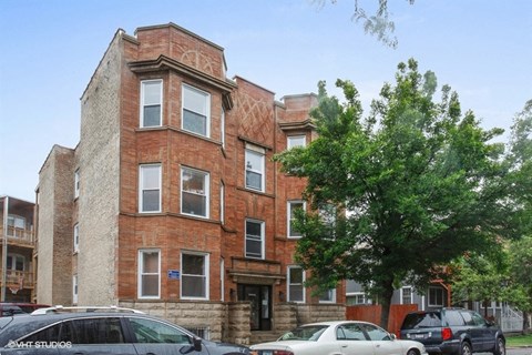 a brick building with cars parked in front of it
