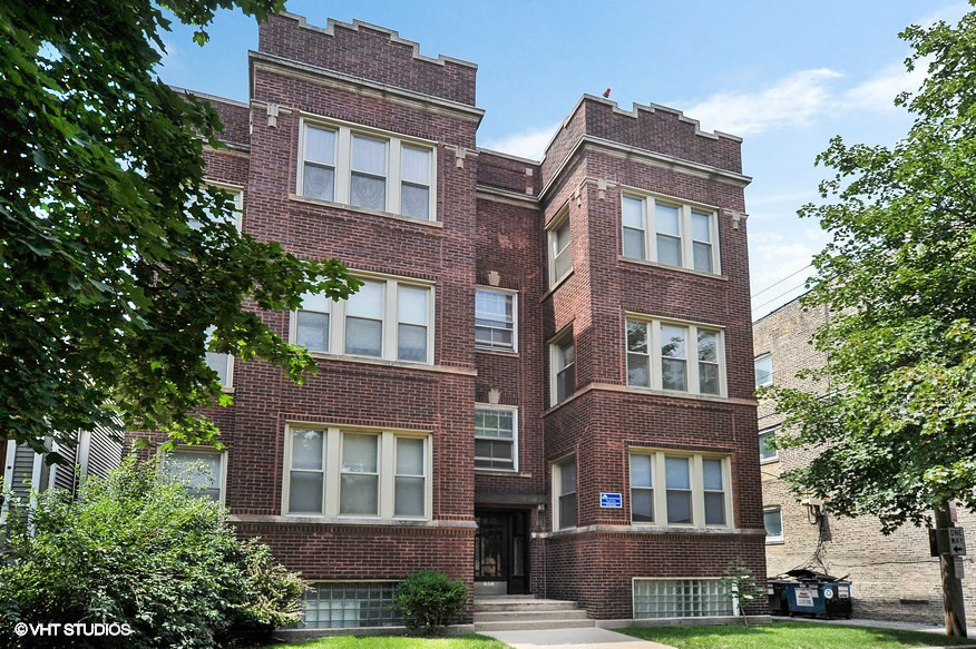 a red brick building with a sidewalk in front