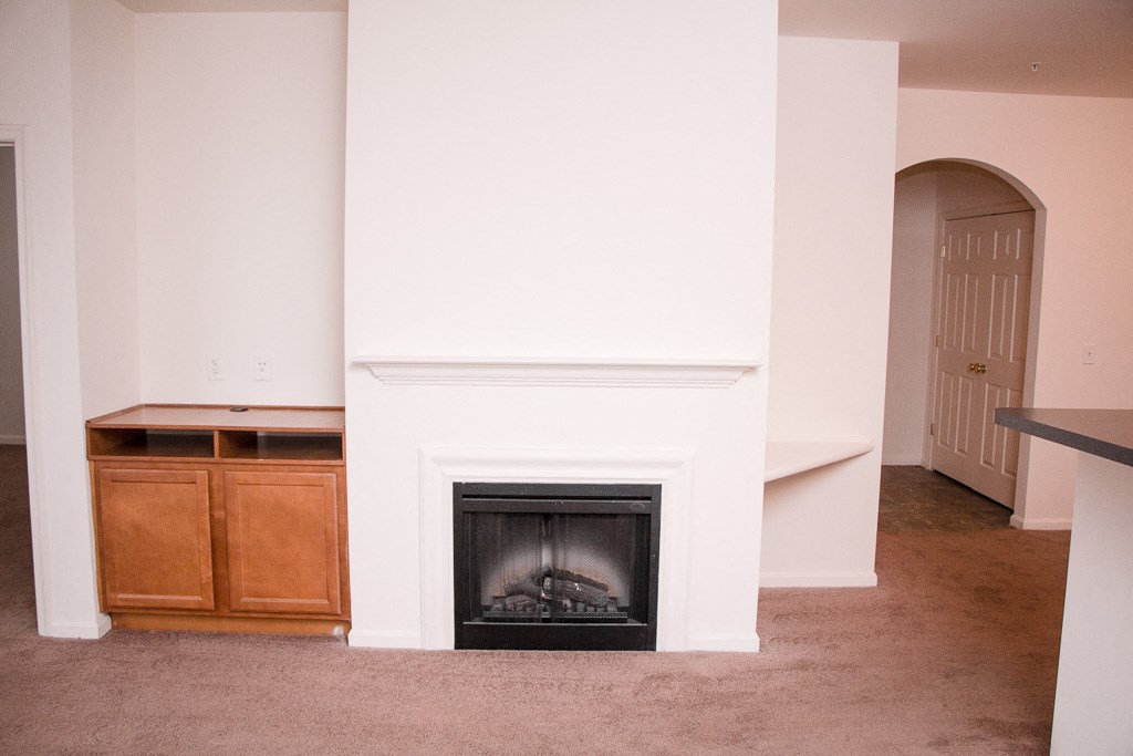 a living room with a fireplace and a white wall