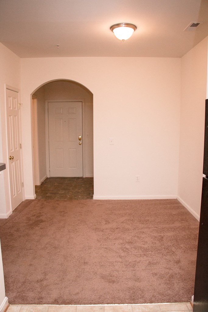 an empty room with a carpeted floor and a white door