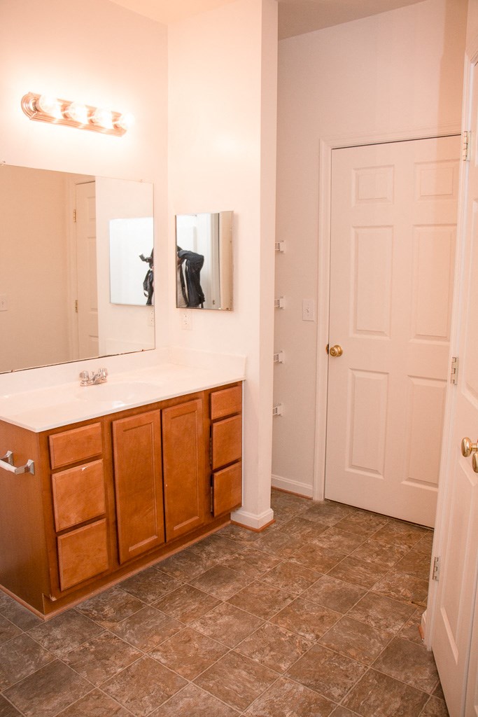a bathroom with a sink and a mirror and a door
