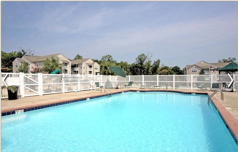 a large blue swimming pool with a white fence around it