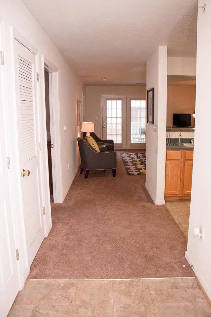 the living room of a home with a couch and a kitchen