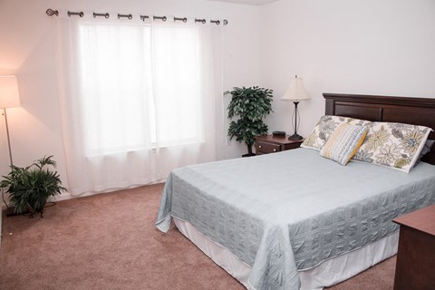 a bedroom with a bed and a large window