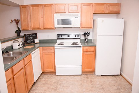 a kitchen with white appliances and wooden cabinets