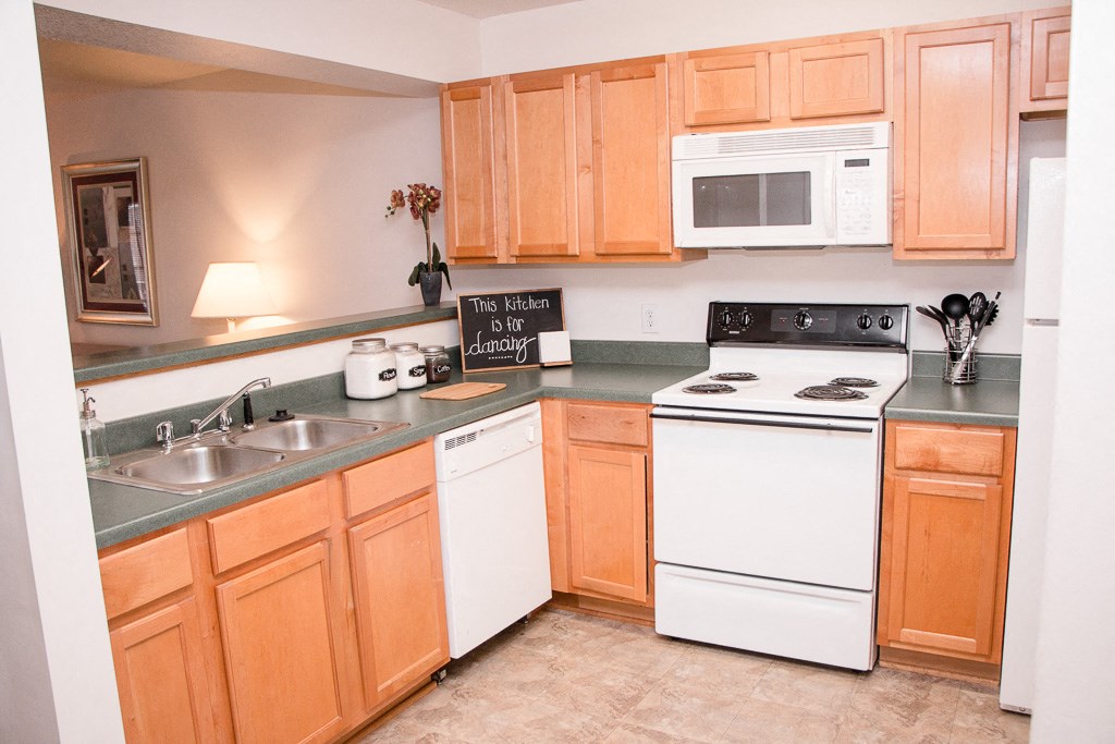 a kitchen with white appliances and wooden cabinets