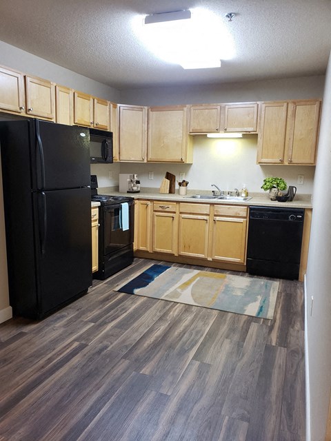 a kitchen with black appliances and wooden cabinets