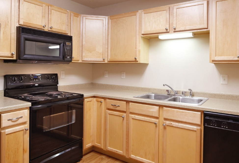 a kitchen with black appliances and wooden cabinets