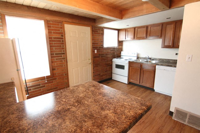 an empty kitchen with a rug in the middle