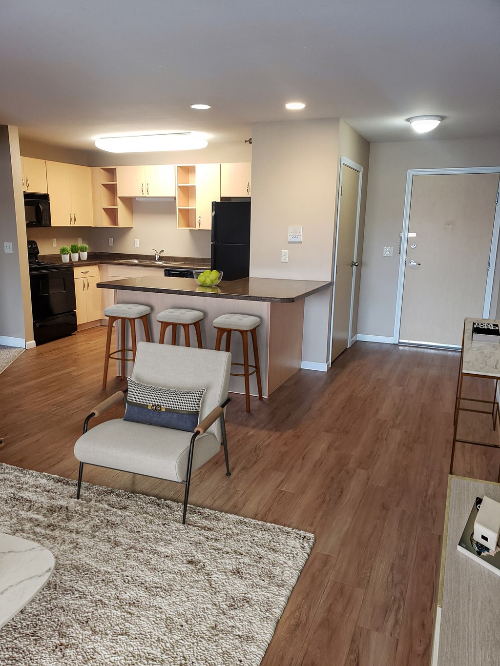 a kitchen and living room with a bar and stools