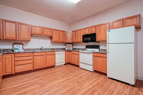 an empty kitchen with wooden cabinets and white appliances