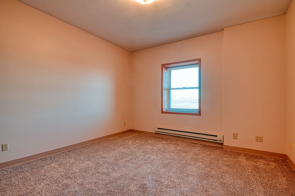an empty room with carpet and a window