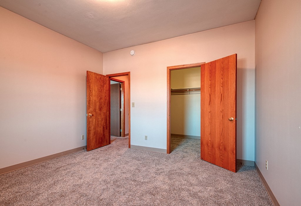 a empty room with two doors and a closet