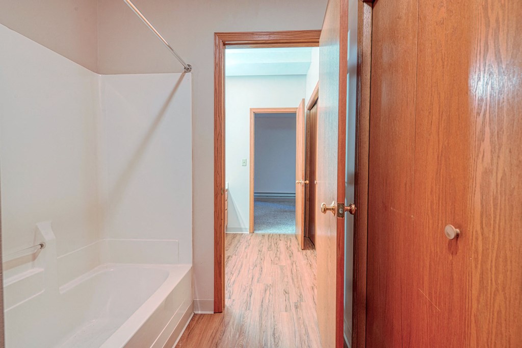 a bathroom with a white tub and a wooden door