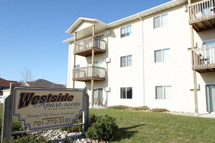 a westside apartments sign in front of a white building