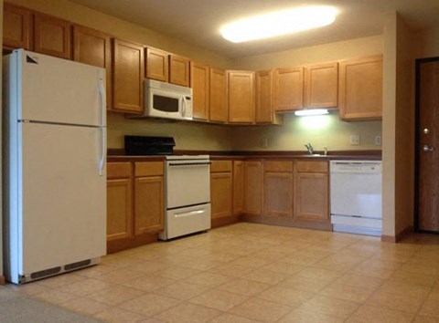 a kitchen with white appliances and wooden cabinets