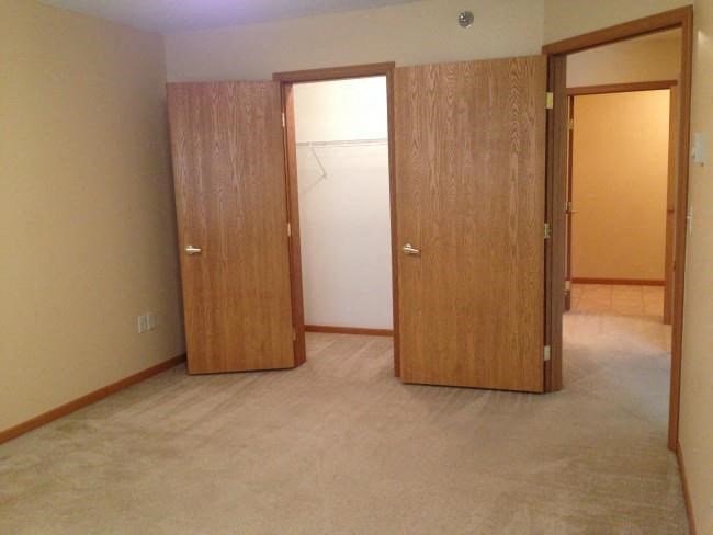 an empty room with a closet and two doors
