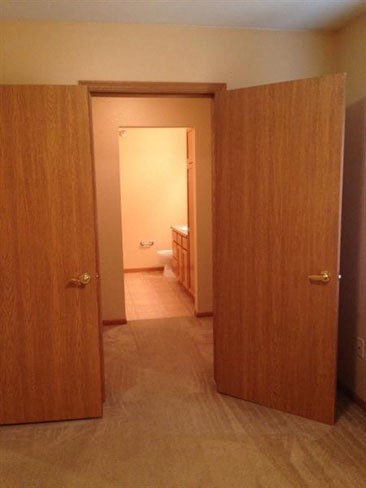 an open door leading to a bathroom with a toilet