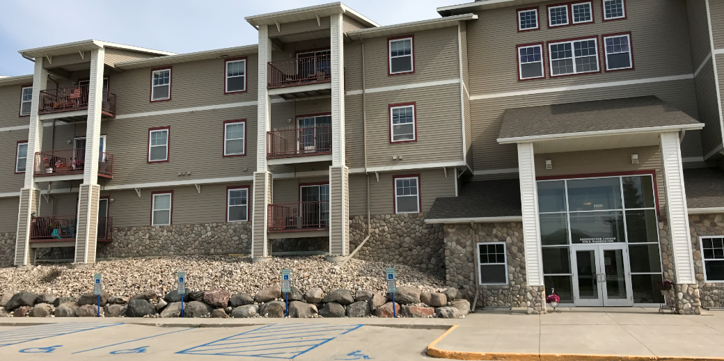 an apartment building with large rocks in front of it