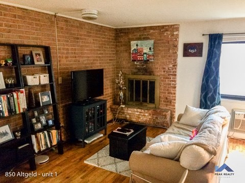 a living room with a couch and a brick fireplace