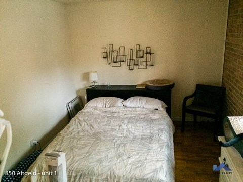 a small bedroom with a bed and a chair
