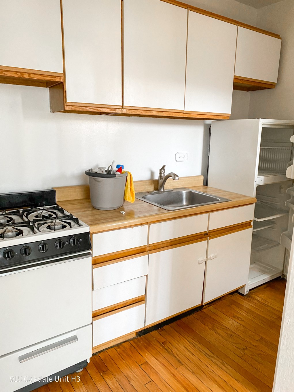 a kitchen with white cabinets and a stove and a sink