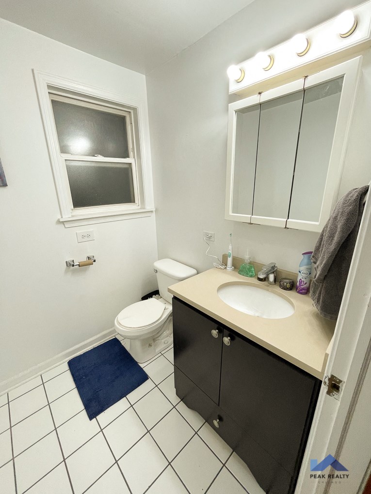 a bathroom with a sink toilet and a window
