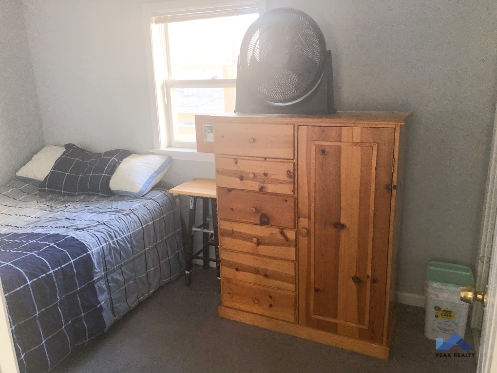 a small bedroom with a bed and a chest of drawers