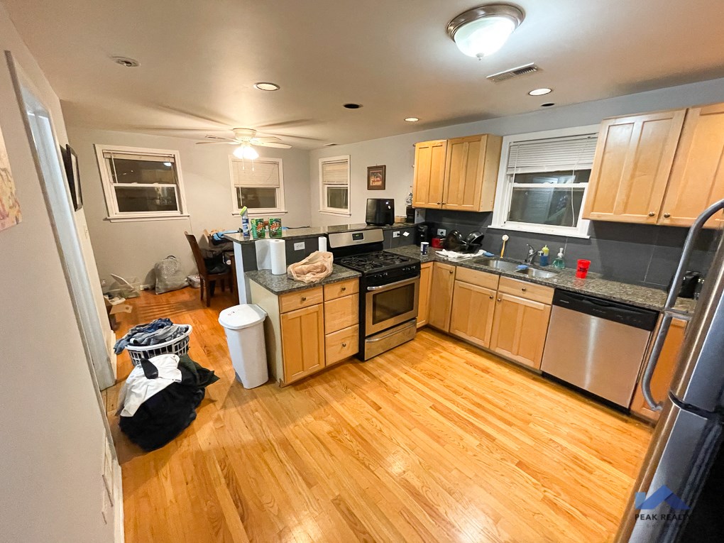 a kitchen with wooden floors and stainless steel appliances