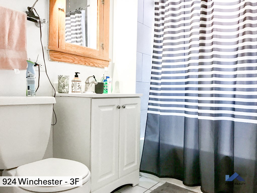 a bathroom with a white toilet and a shower curtain