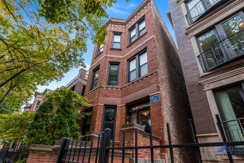 a building with a red brick facade and a black fence
