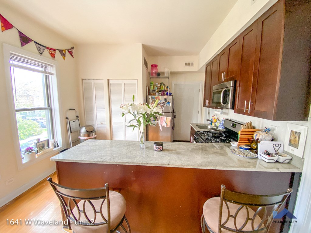 a kitchen with a marble counter top and two chairs