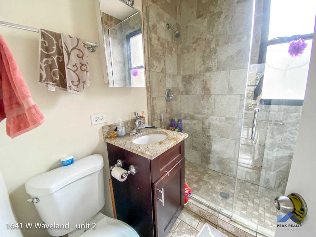 a small bathroom with a shower sink and toilet