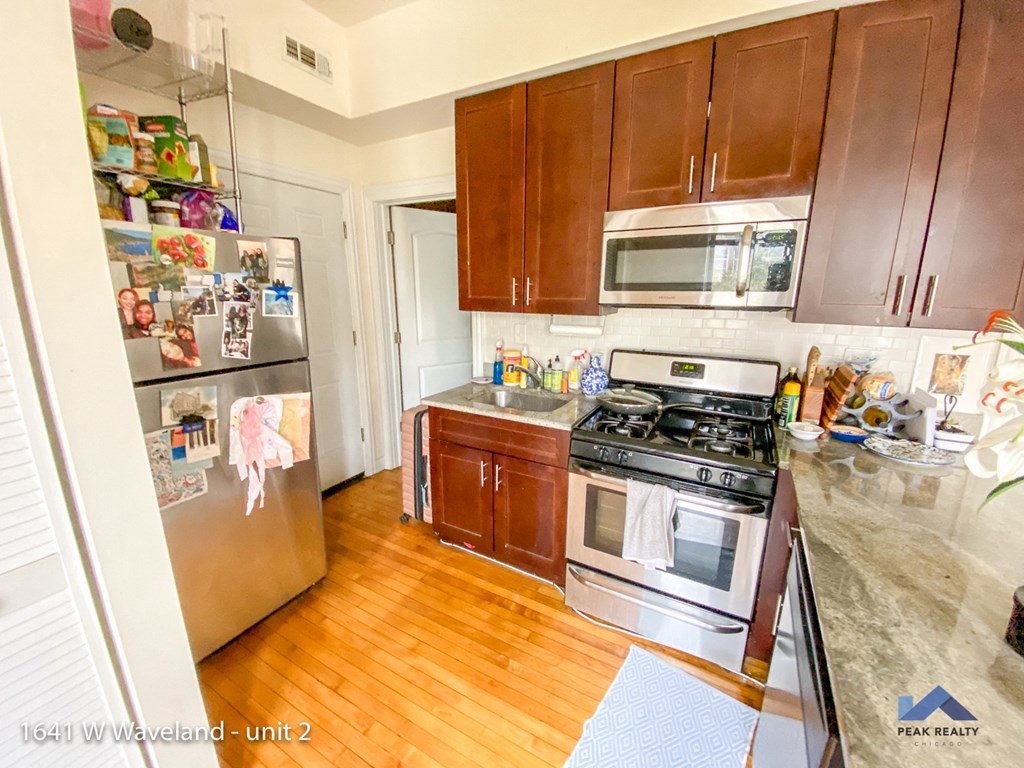 a kitchen with wooden floors and stainless steel appliances