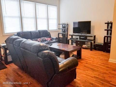 a living room with leather furniture and a tv